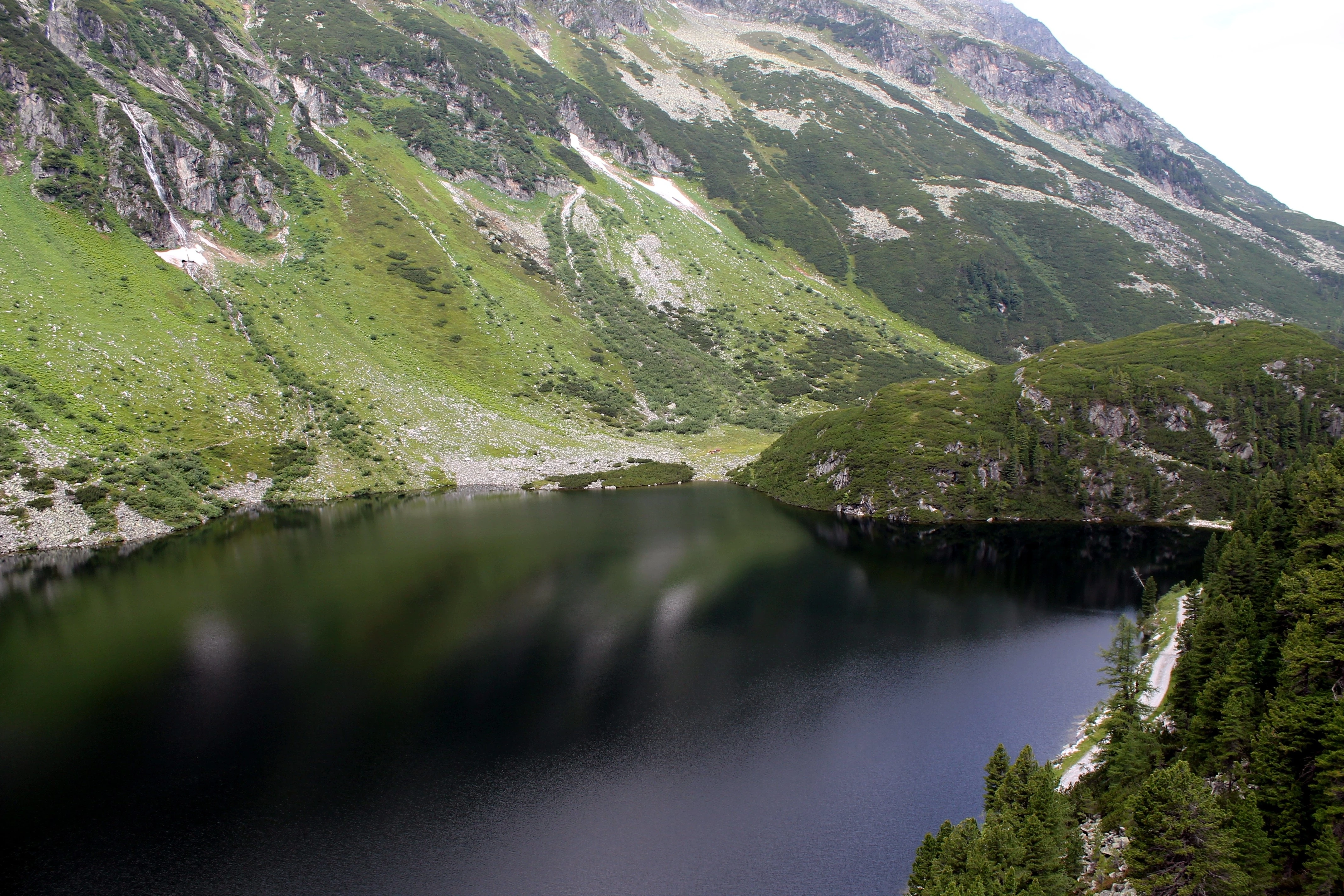 Klidná hladina velkého jezera mezi kopci