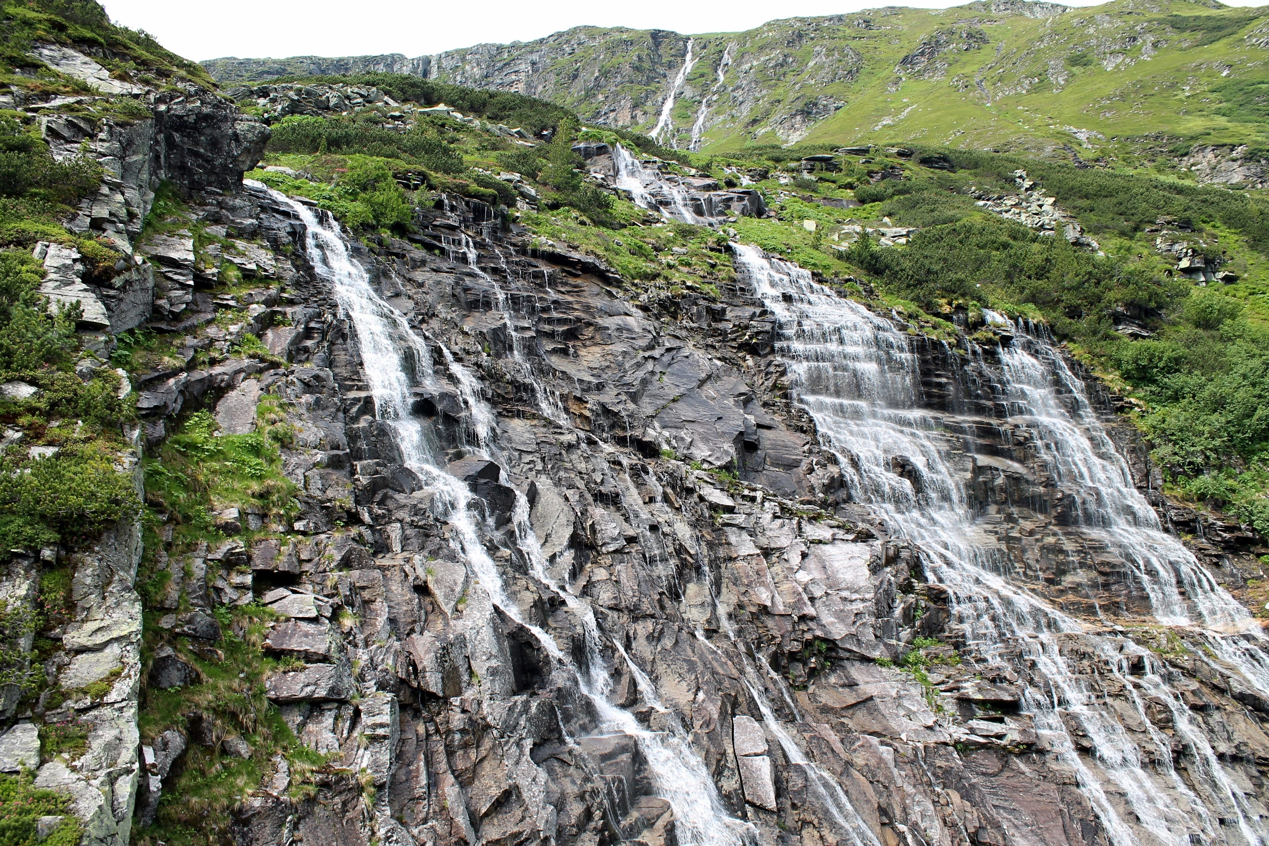 Široký vodopád stékající po tmavé skalní stěně