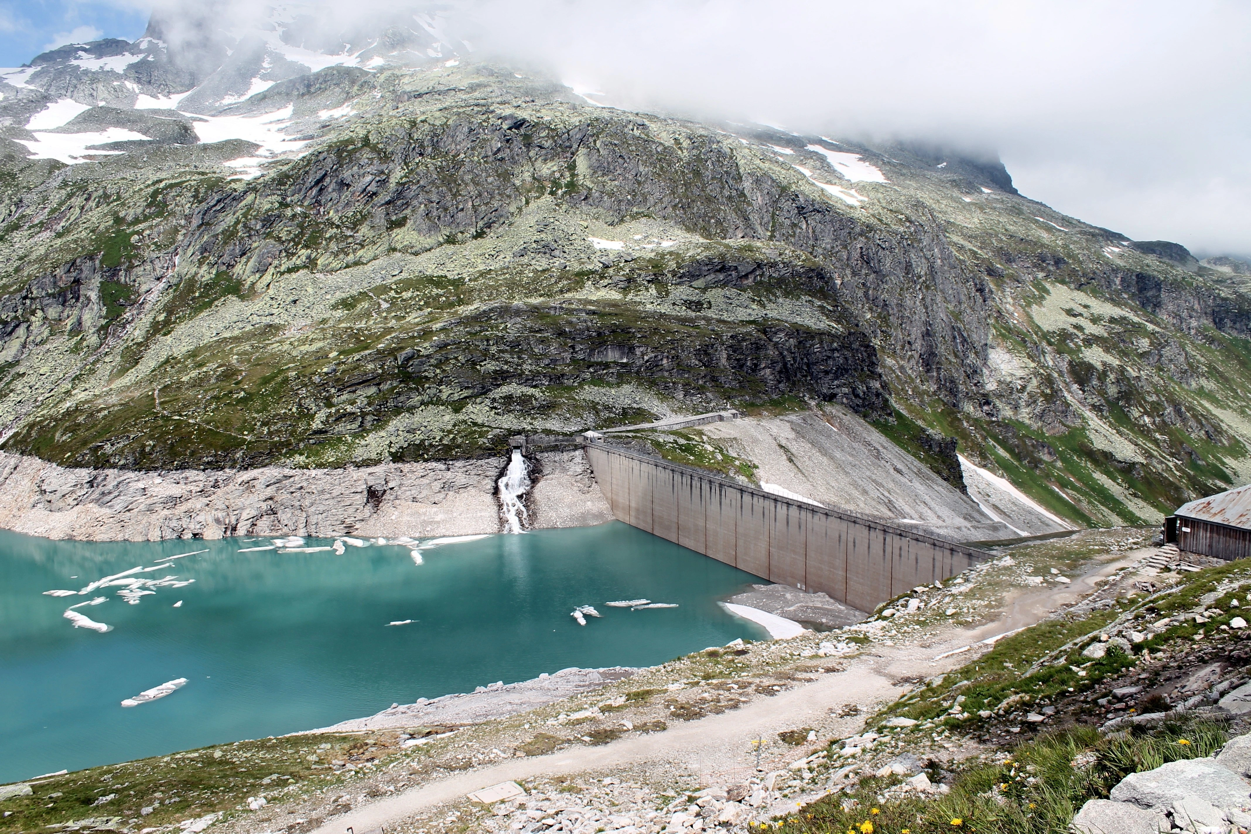 Tyrkysová přehrada sevřená skalami a ledovcovými splazy