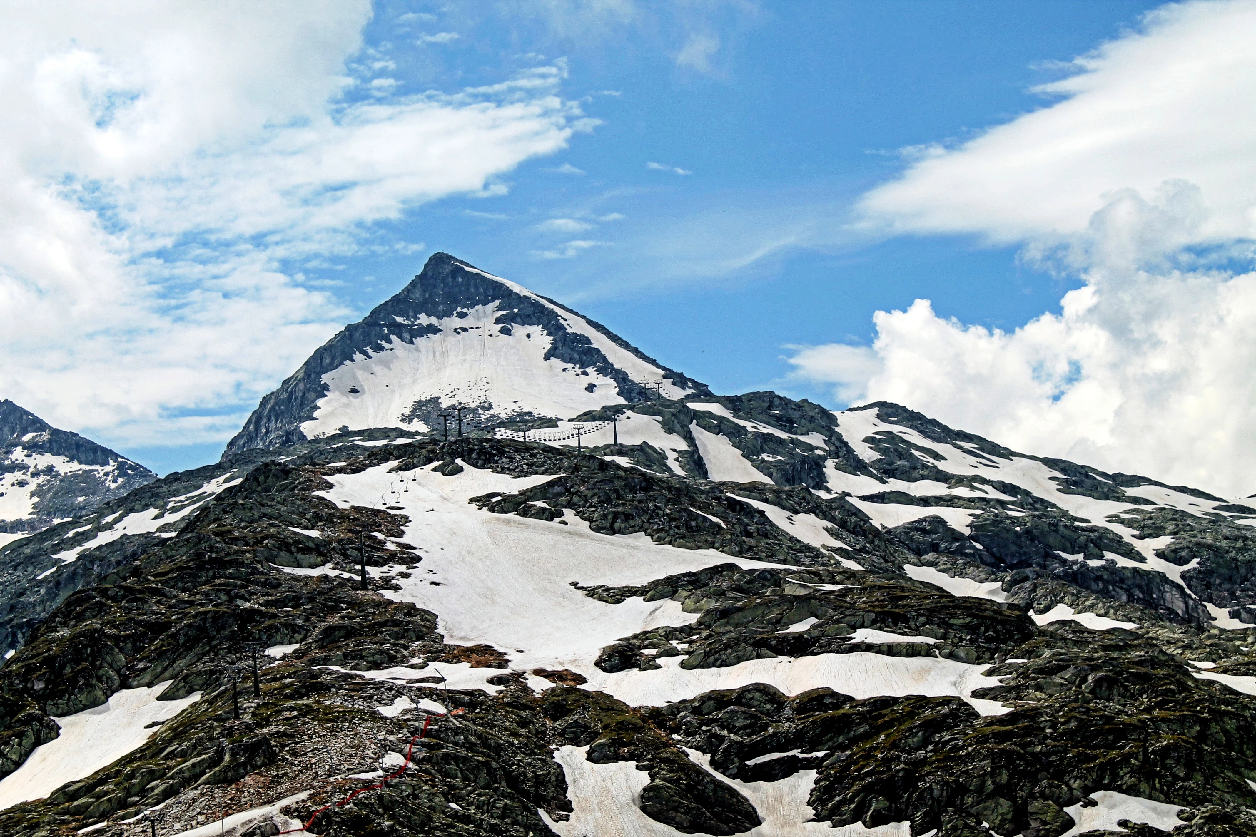 Špičatý skalní štít se sněhem na svazích